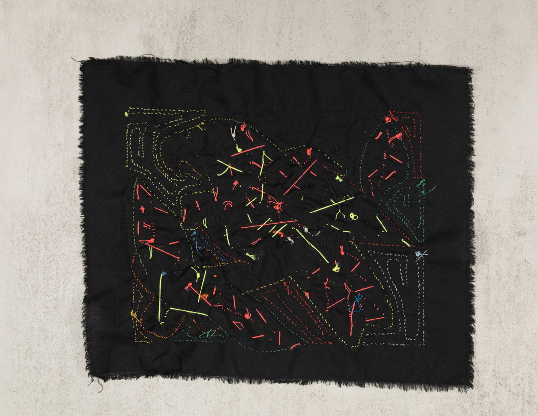 Hand stitched Guna molita from Guna Yala Panama, feathers cut through layered cotton on a black background