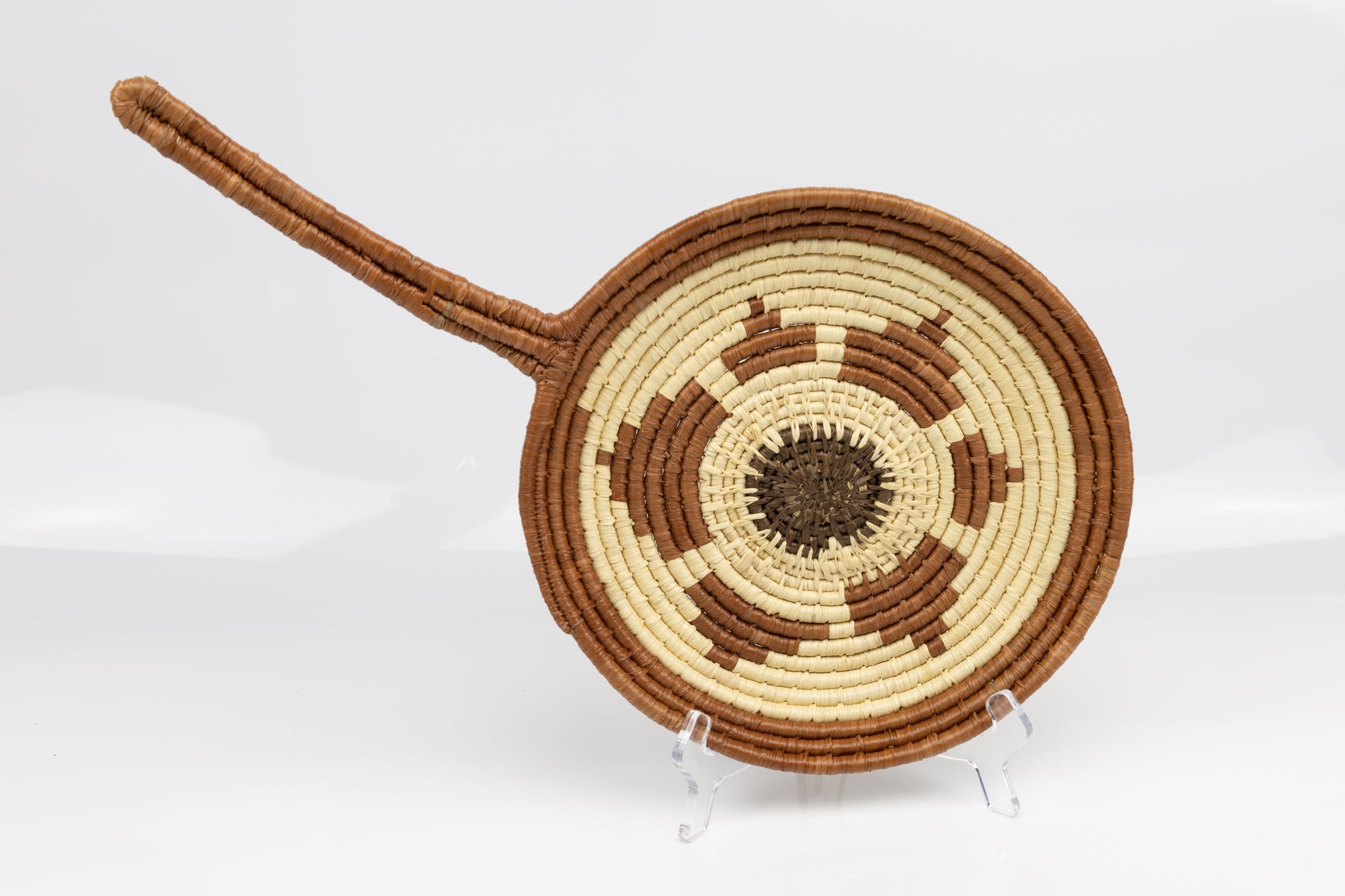 Hand woven plate basket with frying pan design. Palm fiber natural dyes and reed. Woven in Panama.