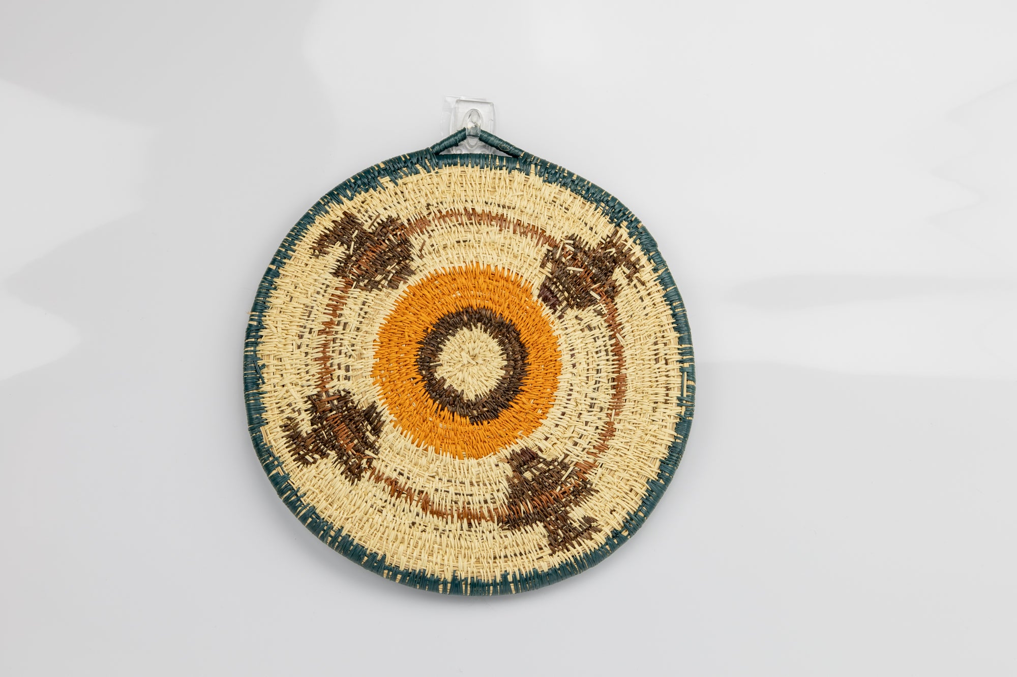 Hand woven plate basket from Panama. blue, gold, brown and white colors. Wall decoration. Indigenous artists Panama.