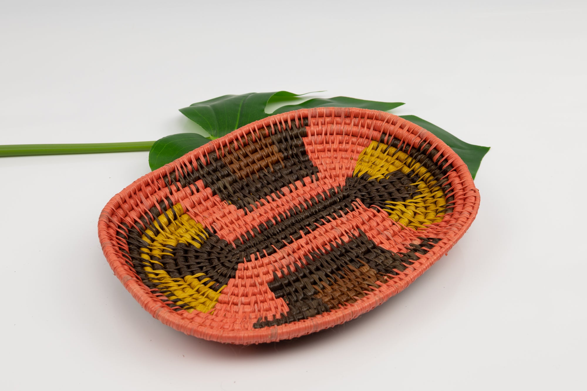 Hand woven plate basket from Panama. Pink, gold, black colors. Wall decoration. Indigenous artists Panama.
