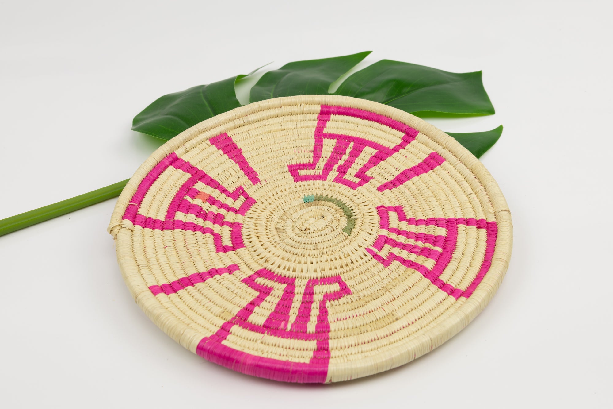 Hand woven plate basket from Panama. Pink and white colors. Wall decoration. Indigenous artists Panama.