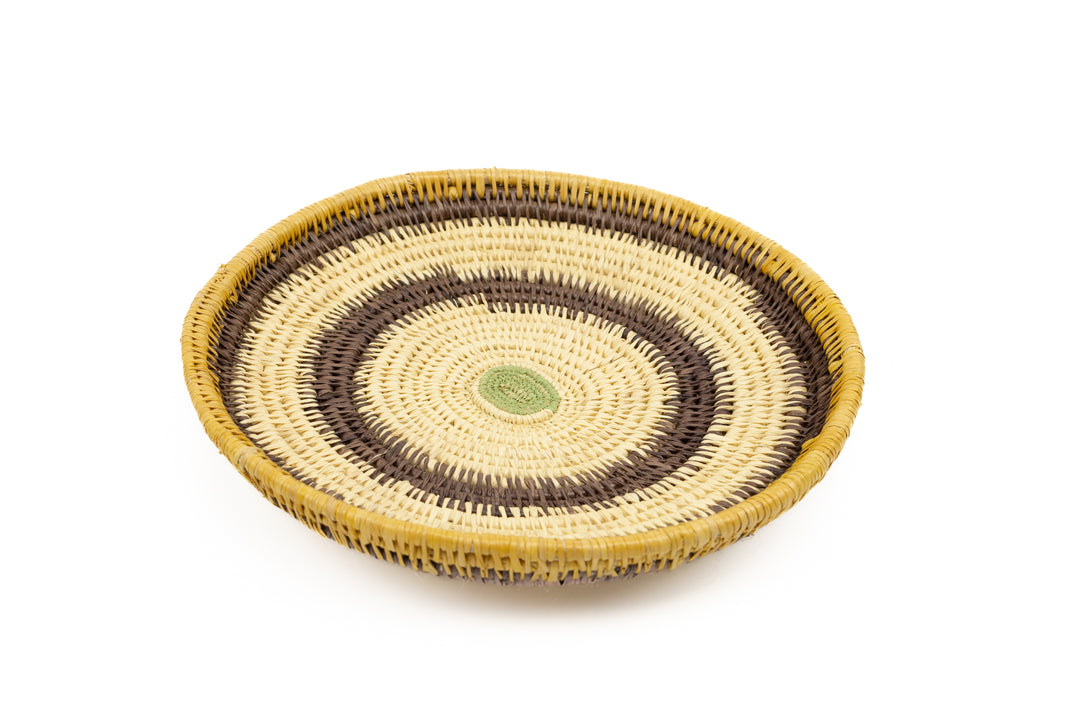 Hand woven plate basket. Palm fiber and natural dyes. Woven in Panama. colors brown and green.