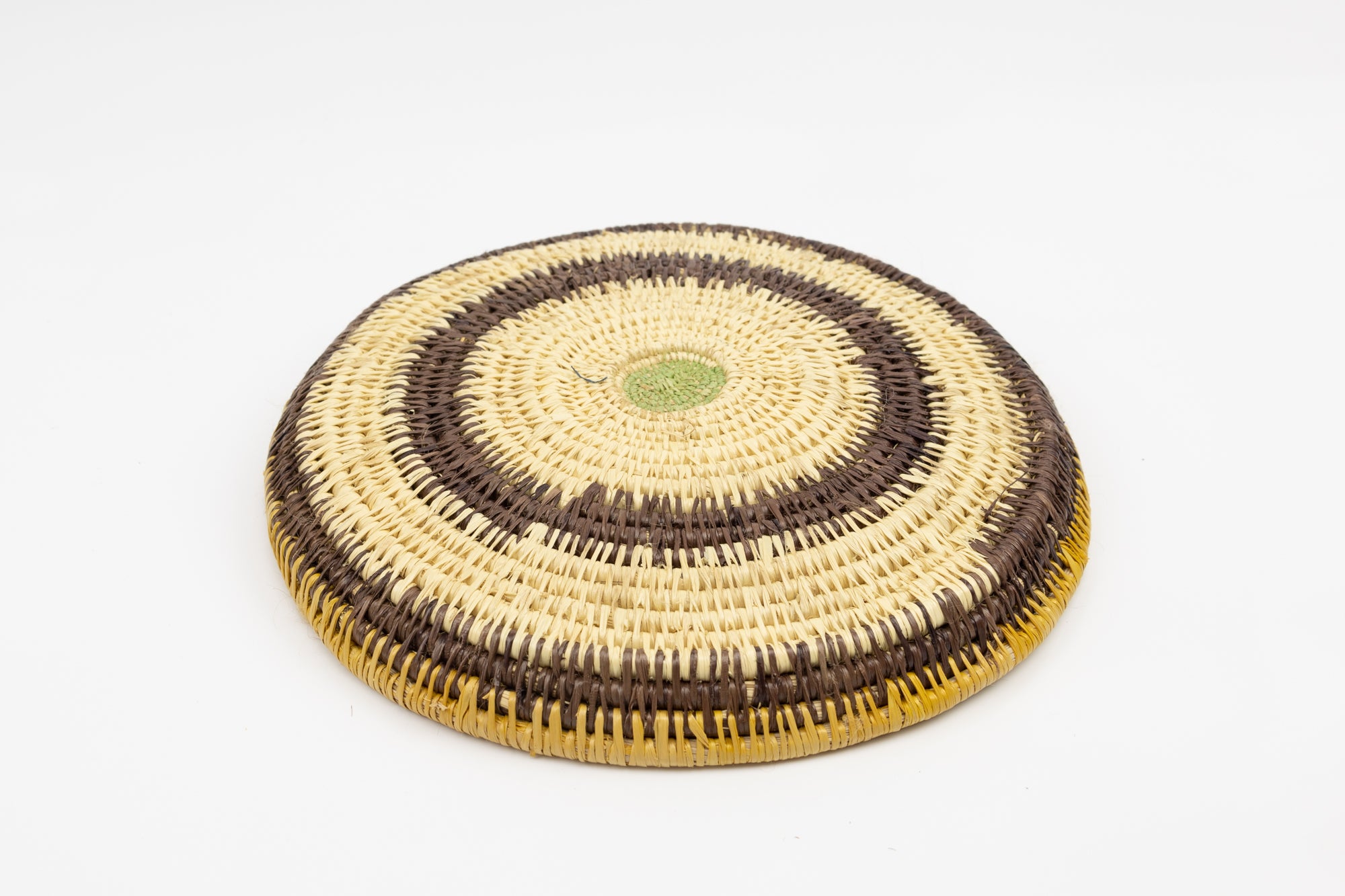 Hand woven plate basket. Palm fiber and natural dyes. Woven in Panama. colors brown and green.