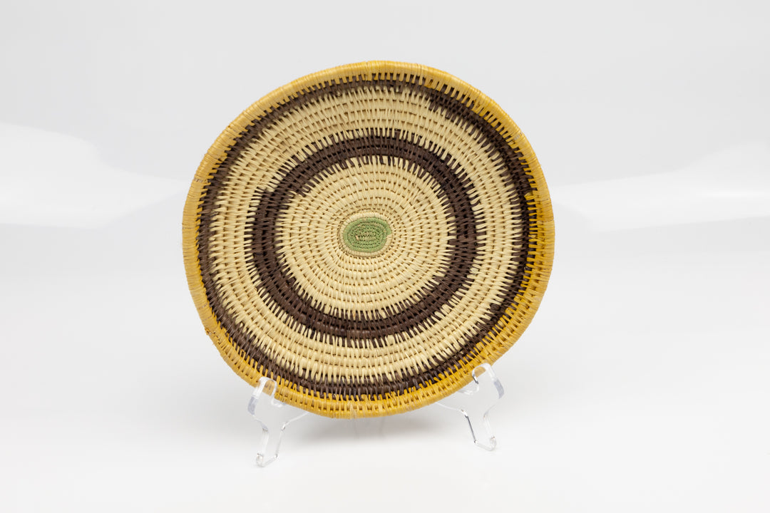 Hand woven plate basket. Palm fiber and natural dyes. Woven in Panama. colors brown and green.