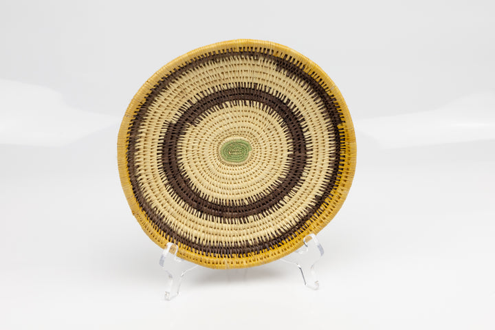 Hand woven plate basket. Palm fiber and natural dyes. Woven in Panama. colors brown and green.