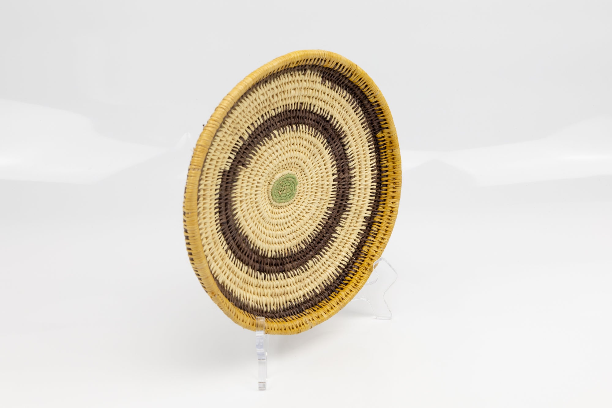 Hand woven plate basket. Palm fiber and natural dyes. Woven in Panama. colors brown and green.
