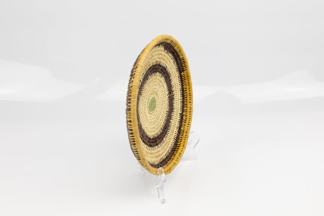 Hand woven plate basket. Palm fiber and natural dyes. Woven in Panama. colors brown and green.