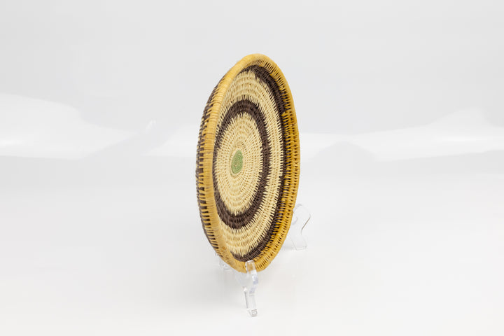 Hand woven plate basket. Palm fiber and natural dyes. Woven in Panama. colors brown and green.