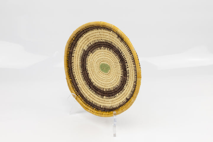 Hand woven plate basket. Palm fiber and natural dyes. Woven in Panama. colors brown and green.