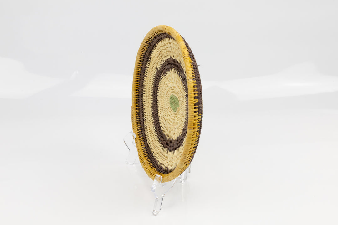 Hand woven plate basket. Palm fiber and natural dyes. Woven in Panama. colors brown and green.