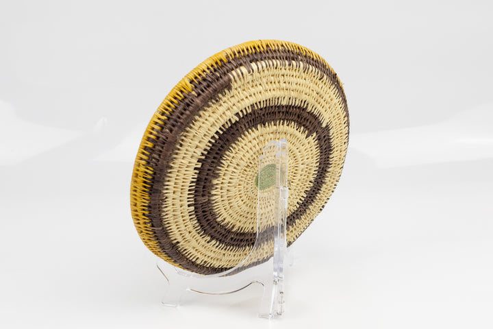 Hand woven plate basket. Palm fiber and natural dyes. Woven in Panama. colors brown and green.