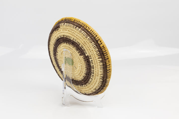 Hand woven plate basket. Palm fiber and natural dyes. Woven in Panama. colors brown and green.