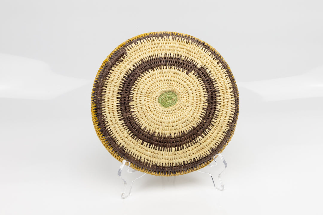 Hand woven plate basket. Palm fiber and natural dyes. Woven in Panama. colors brown and green.