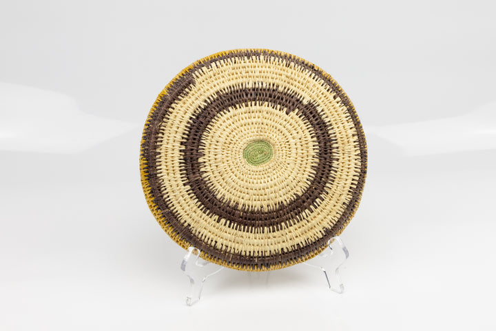Hand woven plate basket. Palm fiber and natural dyes. Woven in Panama. colors brown and green.