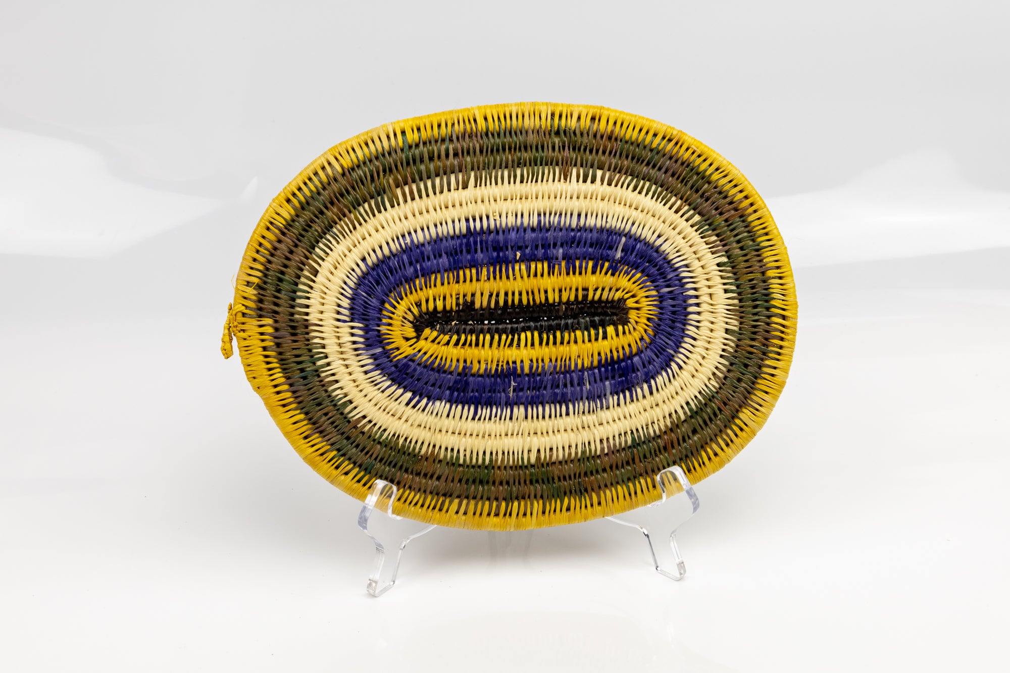 Purple, gold, brown and white. Hand woven plate basket for the wall. Natural dyes. palm fiber. Made in Panama. 