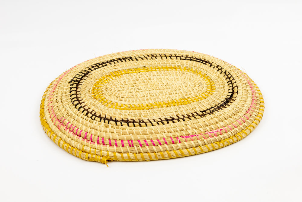 Pink, gold, brown and white. Oval design. Hand woven plate basket. Made in Panama.