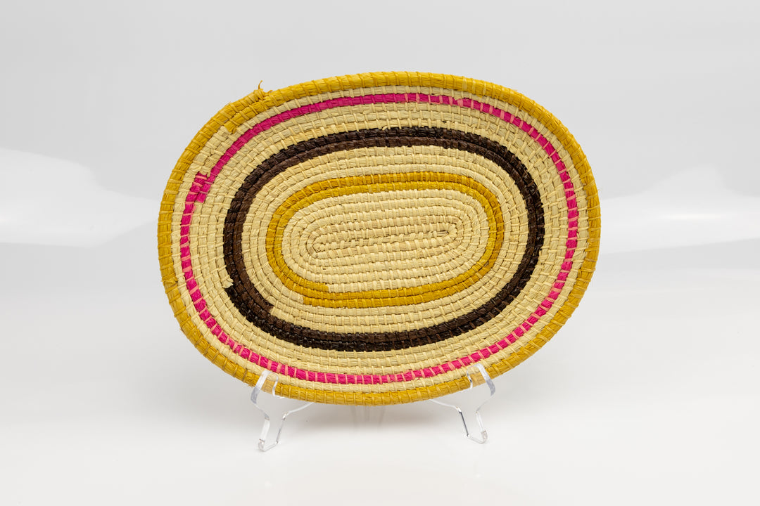 Pink, gold, brown and white. Oval design. Hand woven plate basket. Made in Panama.