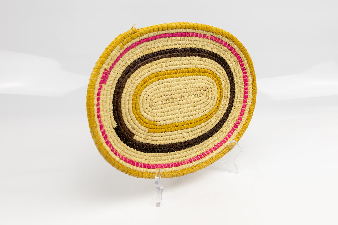 Pink, gold, brown and white. Oval design. Hand woven plate basket. Made in Panama.