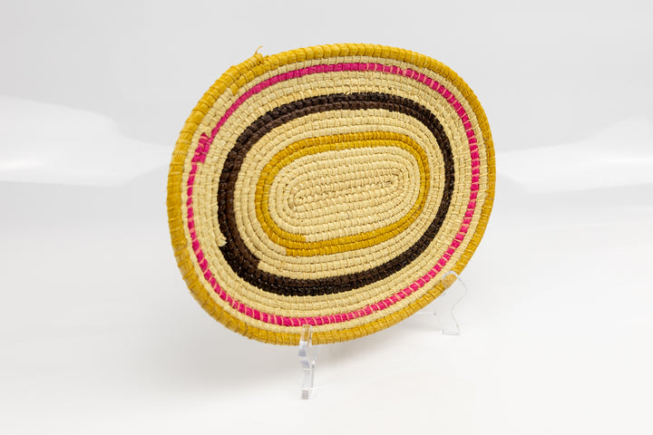 Pink, gold, brown and white. Oval design. Hand woven plate basket. Made in Panama.