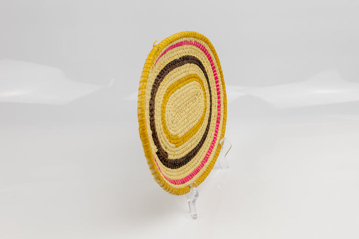Pink, gold, brown and white. Oval design. Hand woven plate basket. Made in Panama.