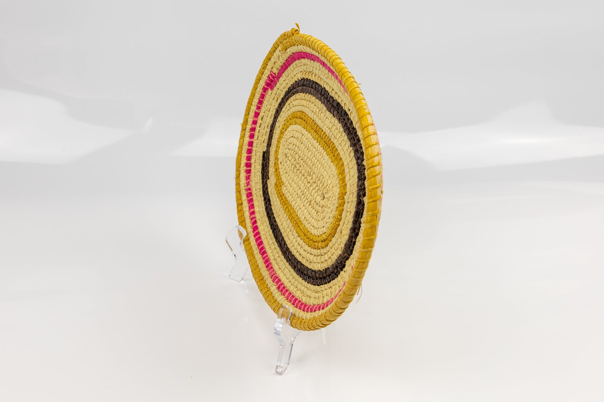 Pink, gold, brown and white. Oval design. Hand woven plate basket. Made in Panama.