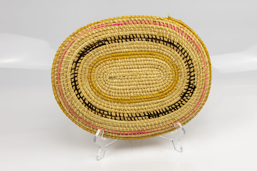 Pink, gold, brown and white. Oval design. Hand woven plate basket. Made in Panama.